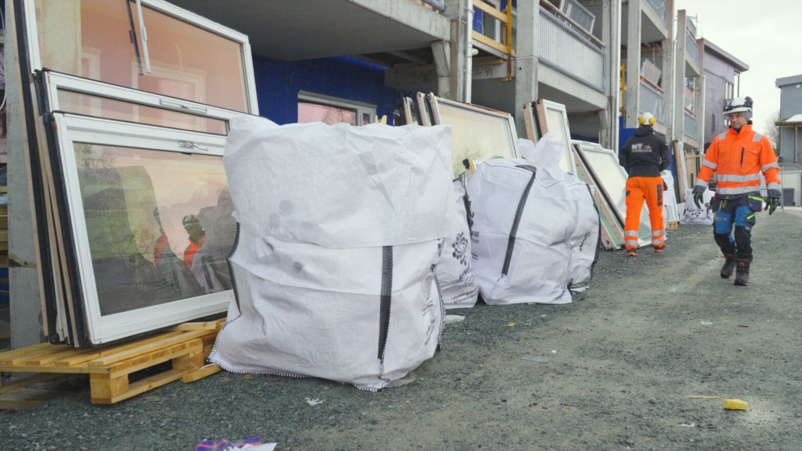 flere big bags står på bakken utenfor et byggeområde