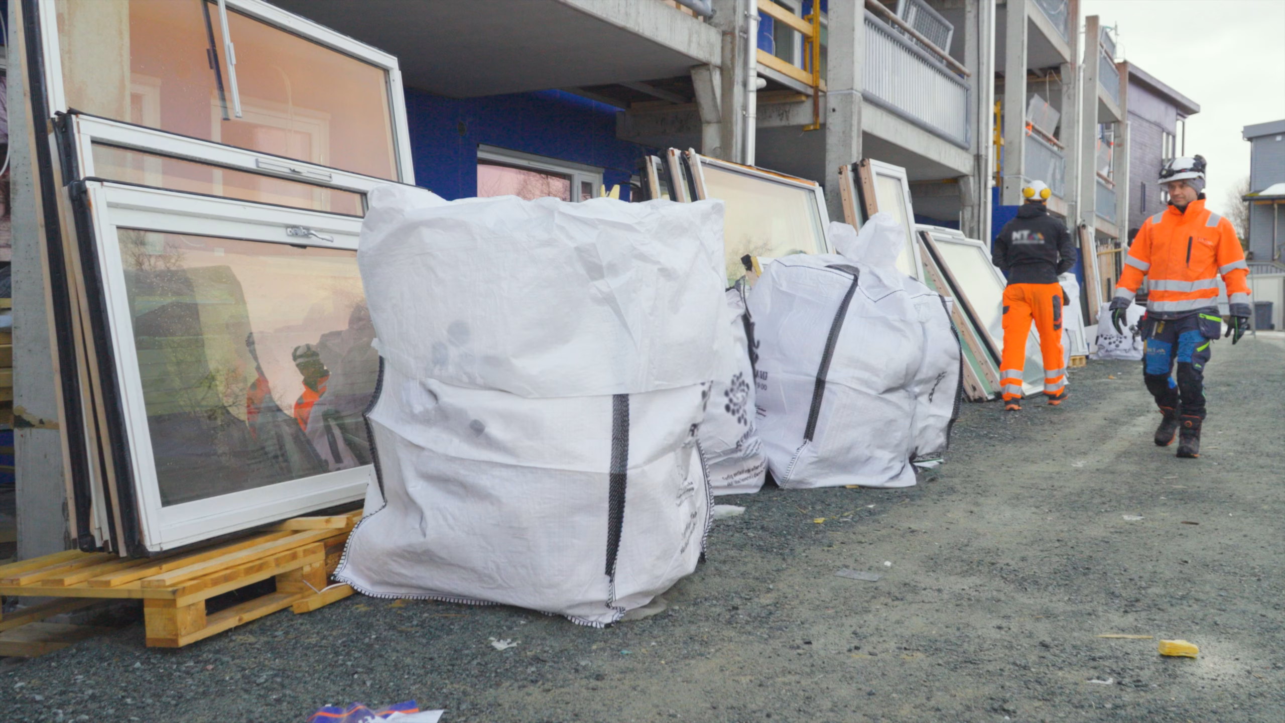 flere big bags står på bakken utenfor et byggeområde